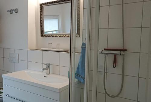 a bathroom with a sink and a shower with a mirror at Haus Marienfried in Rettenberg