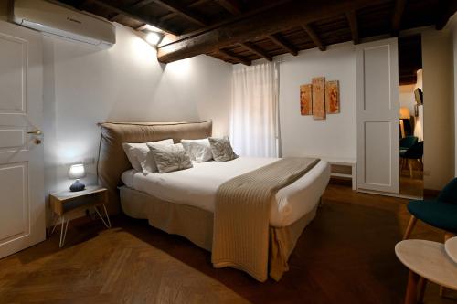 a bedroom with a bed with white sheets and pillows at Residenze Romanae - Vicolo 22 in Rome