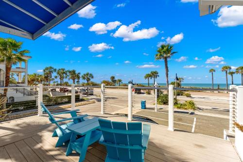 a deck with blue chairs and the beach at Inn on the Beach in St Pete Beach