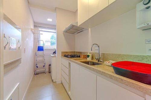 eine Küche mit einem Waschbecken und einer roten Schale auf der Theke in der Unterkunft Rosa Edifício Giovani Pizetta in Gramado