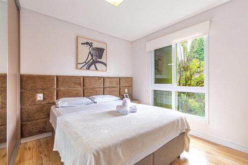 ein Schlafzimmer mit großem Bett und Fenster in der Unterkunft Rosa Edifício Giovani Pizetta in Gramado