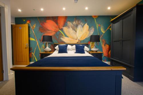 a bedroom with a blue bed with a flower mural at The Flyford in Worcester