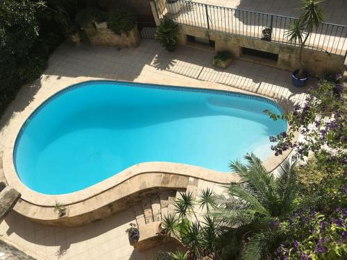 an overhead view of a large blue swimming pool at studio apartment with pool in house of character. in Birkirkara