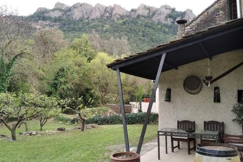 un porche de una casa con mesa y sillas en Casa Rural Barangua en el Pirineo Aragonés, en Santa Cruz de la Serós