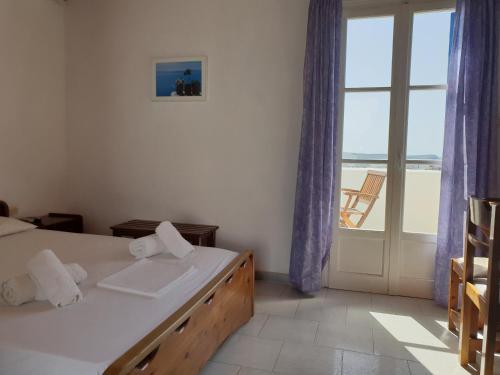 um quarto com uma cama e vista para o oceano em Silver Rocks Hotel em Chrissi Akti
