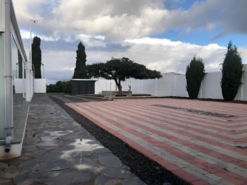 a pathway with a tree in the middle of a building at Los Cipreses in Ingenio