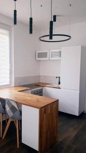 une cuisine avec un comptoir en bois dans une pièce dans l'établissement Hôte Stéphanois Studio & parking, à Saint-Étienne