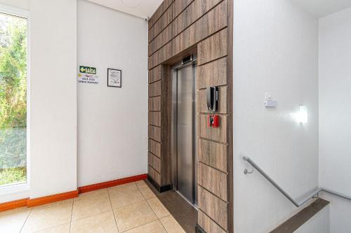 einen Aufzug in einem Zimmer mit einer Holzwand in der Unterkunft Rosa Edifício Parque da Vinícola in Gramado