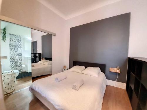 1 dormitorio con 1 cama con 2 toallas en Magnifique Appartement - Hôtel du Parc - VICHY, en Vichy