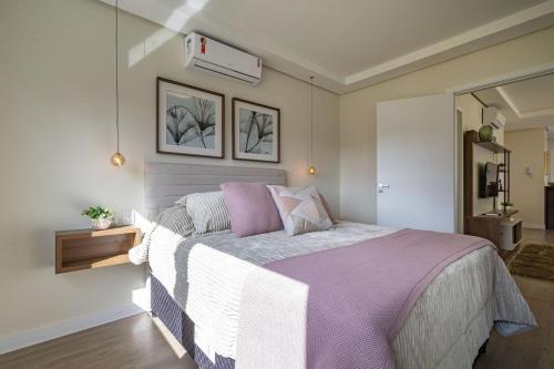 a bedroom with a large bed with a purple blanket at Rosa Edifício Dom in Canela