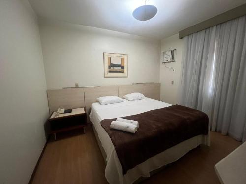 um quarto com uma cama com duas toalhas em Locking's Funcinários 5 em Belo Horizonte