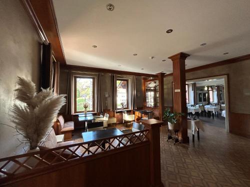 a living room with a lobby with chairs and tables at Auberge Des Mésanges in Meisenthal