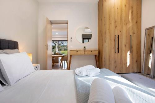 Schlafzimmer mit einem Bett und einem Schreibtisch mit einem Spiegel in der Unterkunft Athina's House in Dhrákas