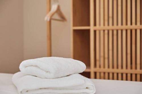 una pila de toallas sentadas encima de una cama en Yuhom, casas con alma, Xacedos 1, en Miño