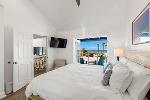 a bedroom with a white bed and a view of the beach at Inn on the Beach in St Pete Beach
