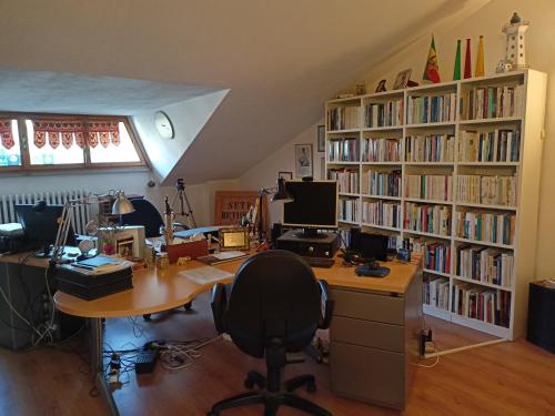 una oficina con escritorio con ordenador y estanterías de libros en Butterfly B&B, en Castrocaro Terme