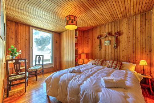 Un dormitorio con una cama grande en una pared de madera. en MAISON ROSE - Relax e vista spettacolare - COUR 0111, en Courmayeur