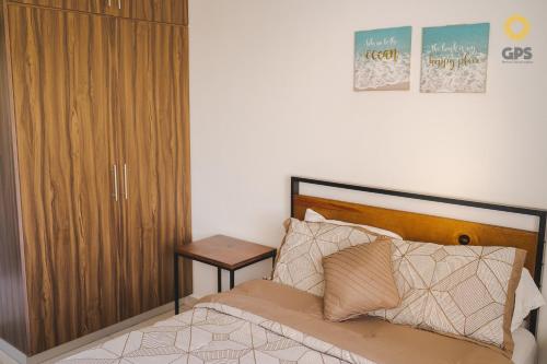 a bedroom with a bed and a wooden cabinet at Palmilla 301,depa 5 min de playa in Mazatlán