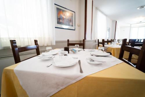a dining room with tables and chairs with white table cloth at Hotel San Pietro in Letojanni