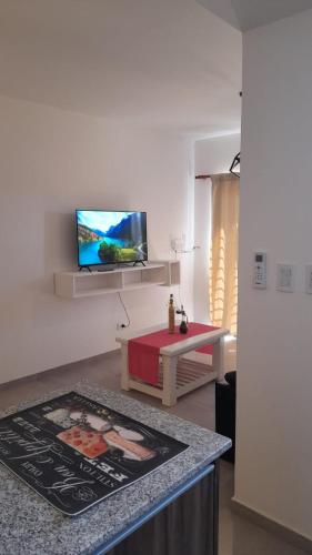 sala de estar con TV de pantalla plana en la pared en Bello Departamento en Gran Mendoza en Godoy Cruz