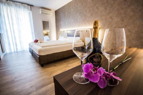 a hotel room with two wine glasses and flowers on a table at Hotel Eden in Torri del Benaco