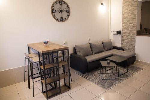 a living room with a couch and a clock on the wall at Studio Apartman SubUrban in Višnjevac
