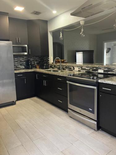 a kitchen with black cabinets and stainless steel appliances at 3 Bedroom Villa in Hollywood Beach in Hollywood