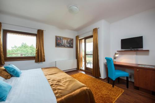 a bedroom with a bed and a desk and a tv at G88 RESIDENCE in Veľká Lomnica