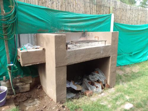 un horno de hormigón con un montón de basura en un patio en Besares en Luján de Cuyo
