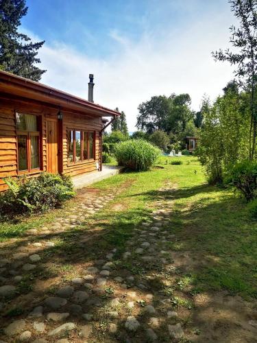 a log cabin with a yard next to a house at Cabanas Mapulauquen in Pucará
