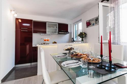 a kitchen with a glass table with food on it at Holiday home Marina-renovated house in city center in Rogoznica