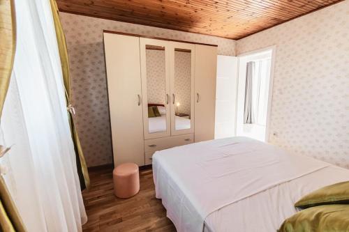 1 dormitorio con cama blanca y espejo en Holiday home Marina-renovated house in city center en Rogoznica