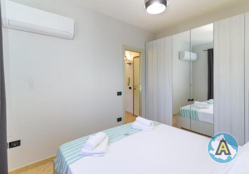 a white room with two beds and a mirror at Comodo a due passi dal mare 46a in Silvi Paese