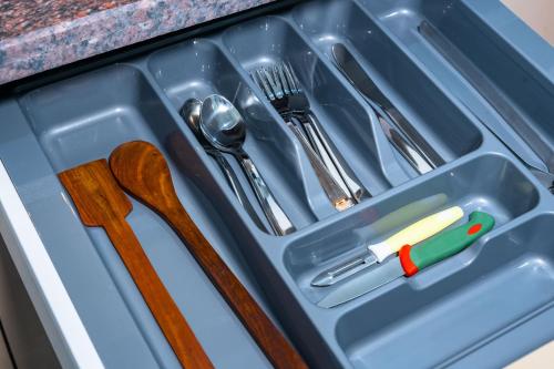 a plastic tray with utensils in a drawer at The Lodgers 1 BHK Serviced Apartment Golf Course Road Gurgaon in Gurgaon