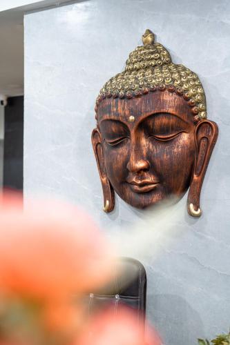 a statue of a head on a wall at The Lodgers 1 BHK Serviced Apartment Golf Course Road Gurgaon in Gurgaon