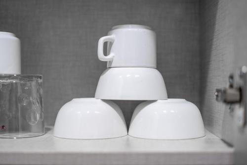 two white cups sitting on top of a counter at The Lodgers 1 BHK Serviced Apartment Golf Course Road Gurgaon in Gurgaon