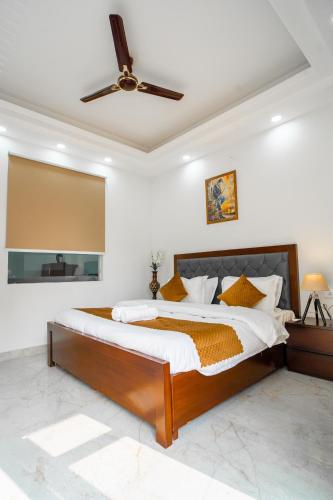 a bedroom with a large bed with a ceiling fan at The Lodgers 1 BHK Serviced Apartment Golf Course Road Gurgaon in Gurgaon