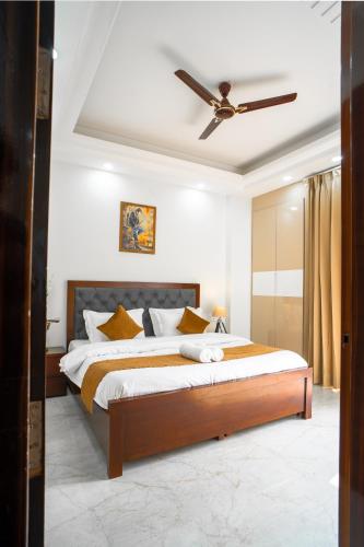 a bedroom with a large bed with a ceiling fan at The Lodgers 1 BHK Serviced Apartment Golf Course Road Gurgaon in Gurgaon