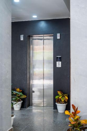 a metal door in a building with potted plants at The Lodgers 1 BHK Serviced Apartment Golf Course Road Gurgaon in Gurgaon