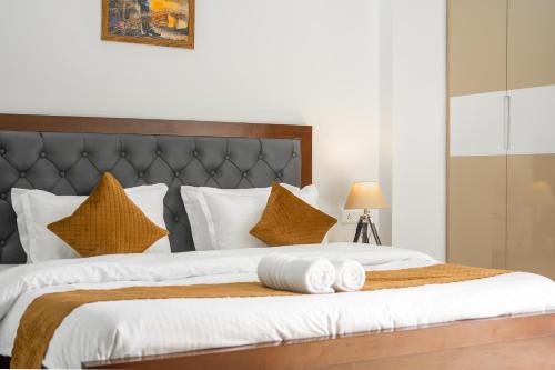 a bedroom with a large bed with two towels on it at The Lodgers 1 BHK Serviced Apartment Golf Course Road Gurgaon in Gurgaon