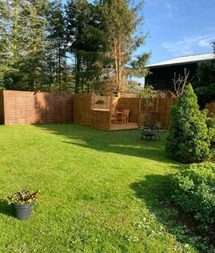 a yard with a fence and a table and chairs at Ferienwohnung An den Tannen in Bartelshagen
