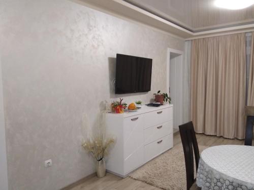 a living room with a tv on a white wall at Apartments Dani in Pomorie
