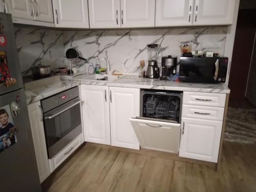 a kitchen with white appliances and white cabinets at Apartments Dani in Pomorie