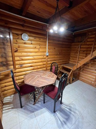 ein Holzzimmer mit einem Tisch und 2 Stühlen in der Unterkunft Cabaña in La Rioja