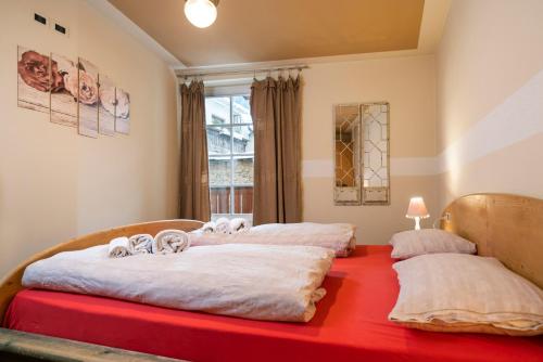 duas camas num quarto com uma mesa vermelha em Ciasa Gianot em Moena