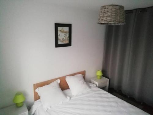 1 dormitorio con 1 cama con sábanas blancas y 2 lámparas en Maison au calme à 300m de la plage en La Cotinière