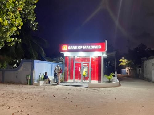 a gas station with people standing outside at night at Mathiveri Thundi Inn in Mathiveri
