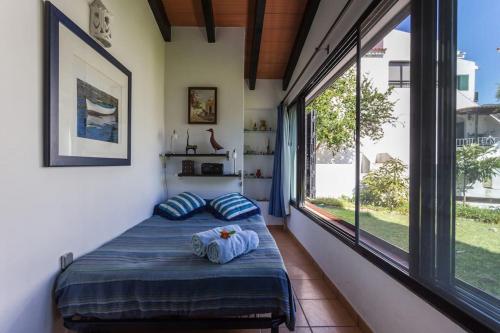 My cozy BEACH HOUSE في تافيرا: غرفة نوم بسرير ونافذة كبيرة