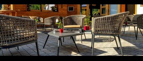 - un ensemble de chaises et d'une table sur une terrasse dans l'établissement Restaurant Les Vérines, à Chamoson