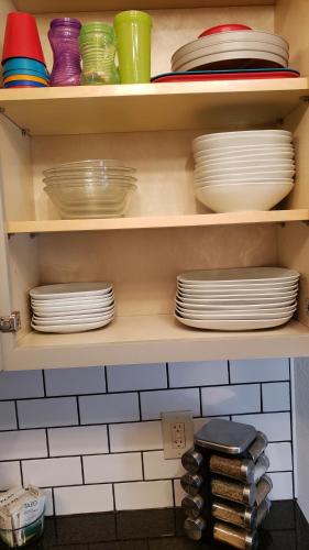 a shelf filled with plates and bowls and dishes at Lake front Studio in Little Elm